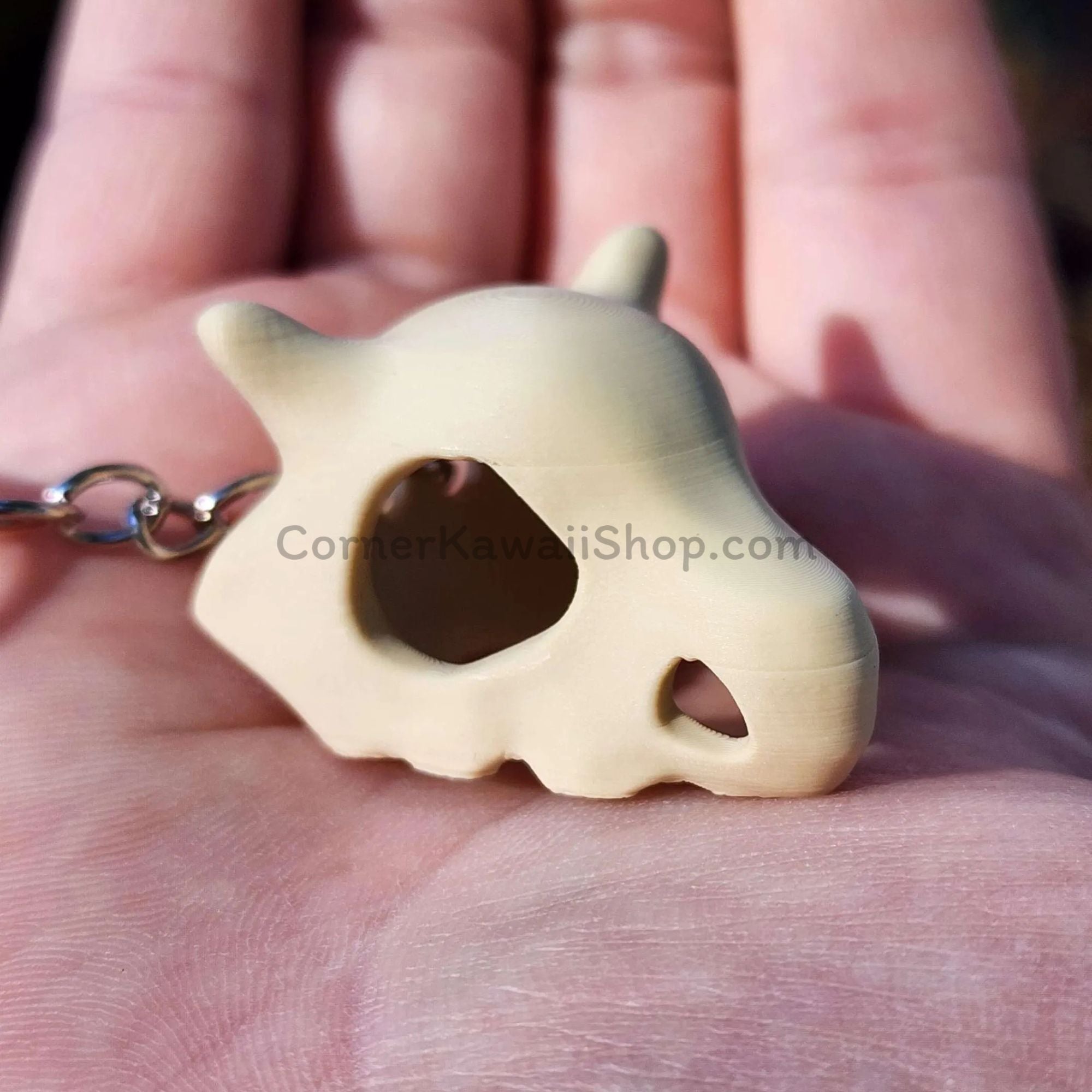 Cubone skull keychain size comparison with hand